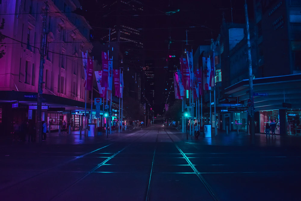 Stradă urbană fotografiată noaptea în lumină violet și albastră